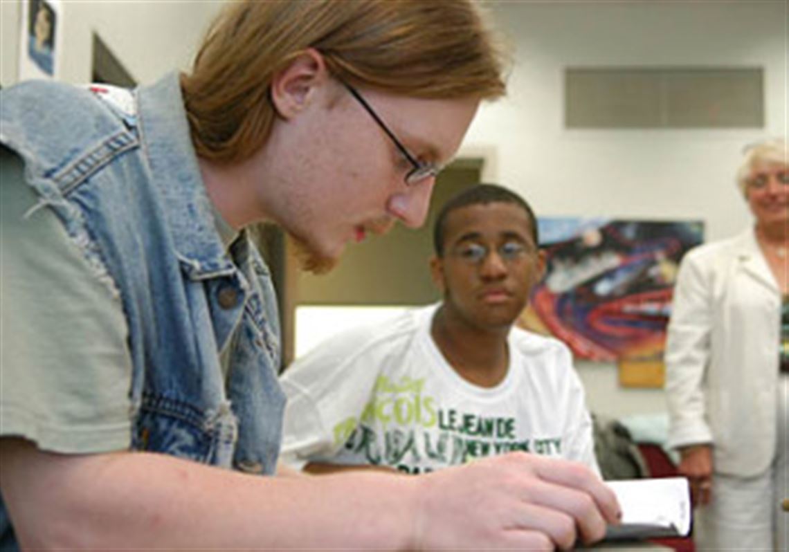 Bennett Shakoske, left, reads a passage out loud  at the Duquesne University Reading Clinic in July as  Jeff Brown, right, listens.