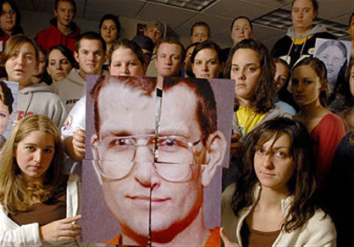 Members of the Forensic Investigation I class at Duquesne University hold a photo of convicted serial killer Keith Hunter Jesperson, with whom they corresponded during the fall semester. Other students hold photos of Mr. Jesperson's victims.