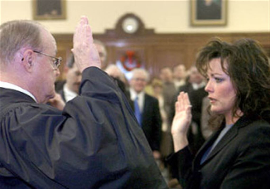 Judge Gerard M. Bigley administers the oath of office yesterday to his daughter, Kelly Eileen Bigley, creating the first father-daughter combination in the court's history.