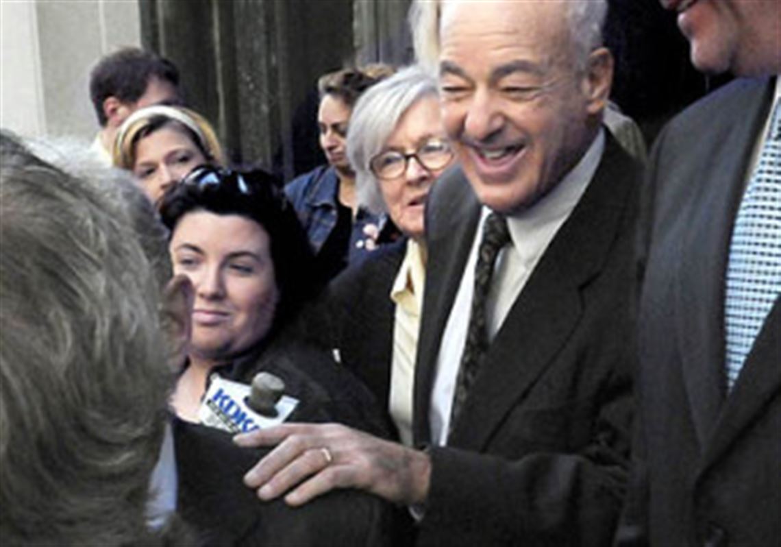 Former Coroner Dr. Cyril H. Wecht leaves the federal courthouse yesterday after a mistrial was declared in his case. At left is his wife, Sigrid.