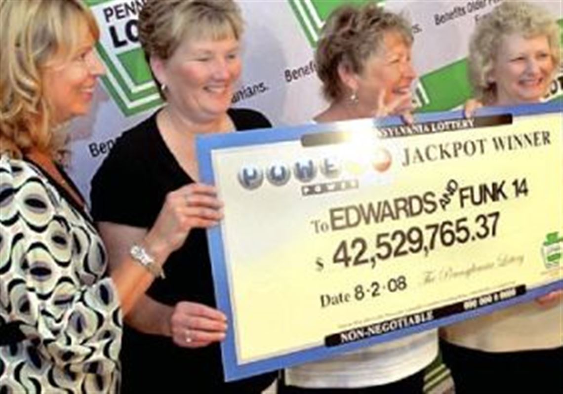 Jean Edwards, second from right, who with her husband is sharing a $42.5 million Powerball jackpot with a dozen relatives, poses with the check. With Jean are, from left to right, Melanie Funk, Yvonne Edwards and Linda Edwards.