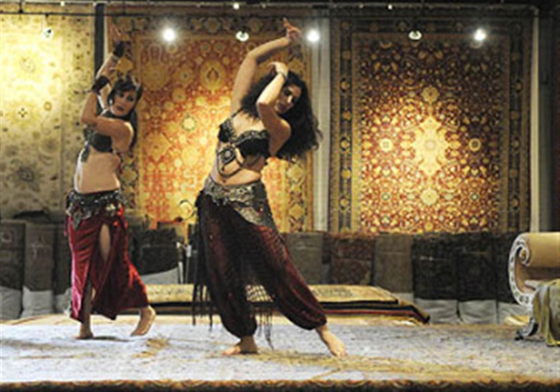 Cristina Nassif, playing Djamileh (center) and Maria Hamer, Nassif''s belly dancing assistant from the Zafira Dance Company, perform in Artifacts, a carpet warehouse in the West End, as part of the Opera Theater of Pittsburgh's production of "Djamileh."