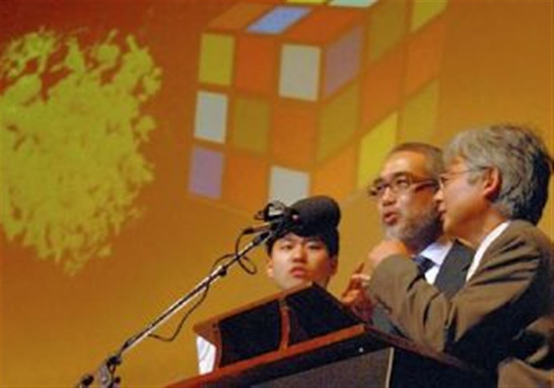 Toshiyuki Nakagaki, of Hokkaido University, Japan, center, and fellow winners of the Ig Nobel Prize for Cognitive Science ("Intelligence: Maze-Solving by an Amoeboid Organism") give their Thursday acceptance speech in three-part harmony. Their research showed that slime molds can solve puzzles.