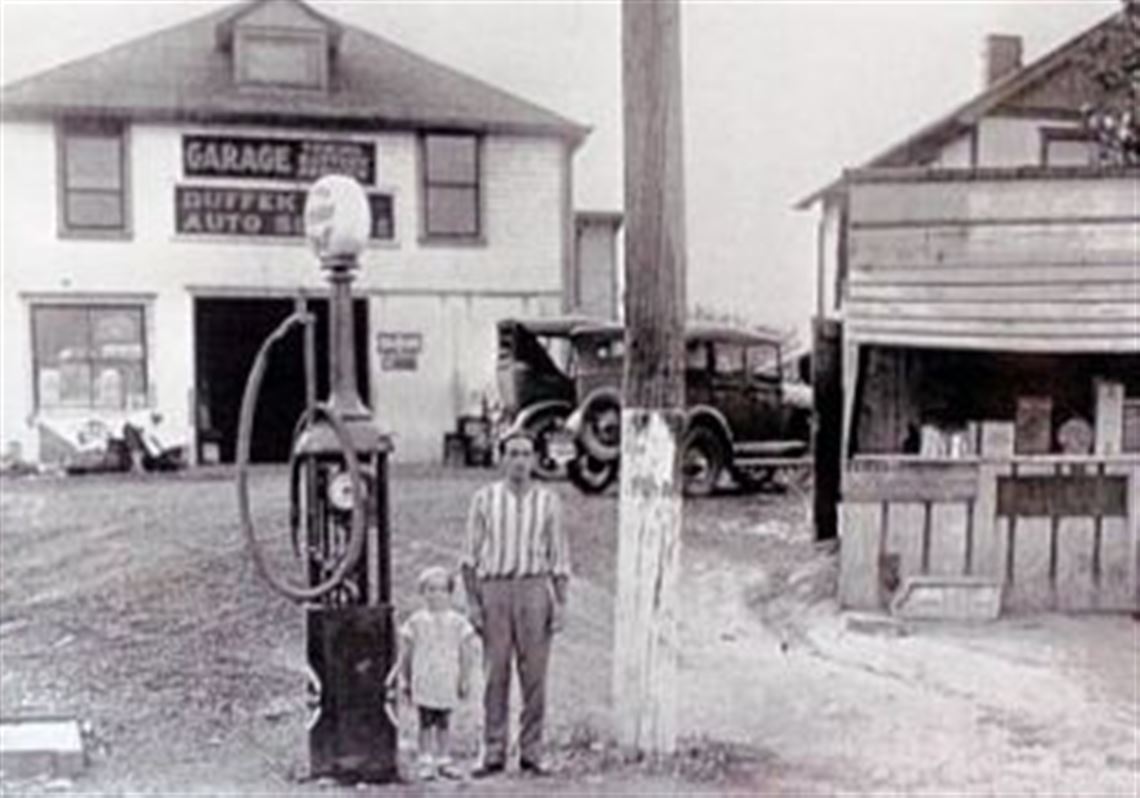 This photograph, from around 1929, shows the auto business next to Mr. Palermo's home behind a roadside stand.