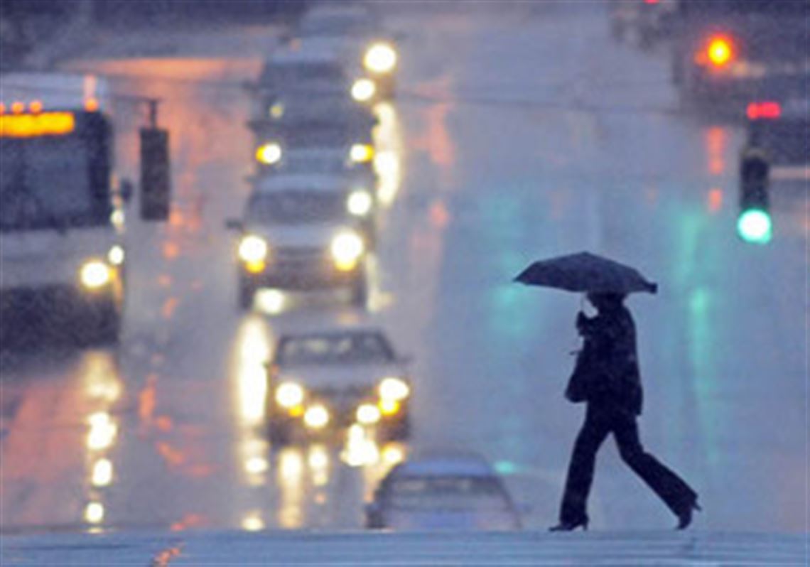 Braced against the snow and wind, a pedestrian this morning crosses the Boulevard of the Allies at Market Street, Downtown.
