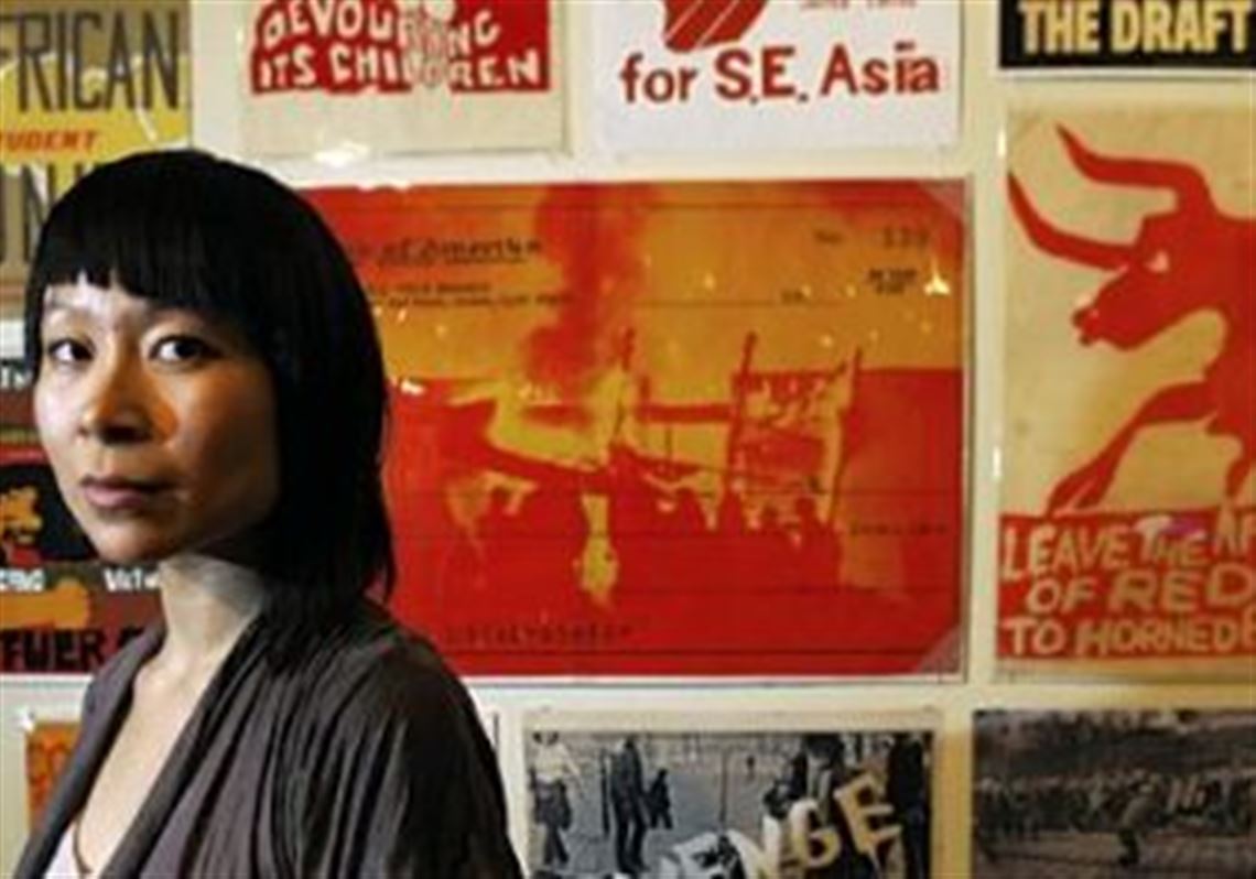 Astria Suparak, who became director of the Miller Gallery at Carnegie Mellon University last year, stands before some of the artwork in "Signs of Change: Social Movement Cultures 1960s to Now," an exhibition guest-curated by Dara Greenwald and Josh MacPhee that premiered at Exit Art, New York, and continues here through March 8.