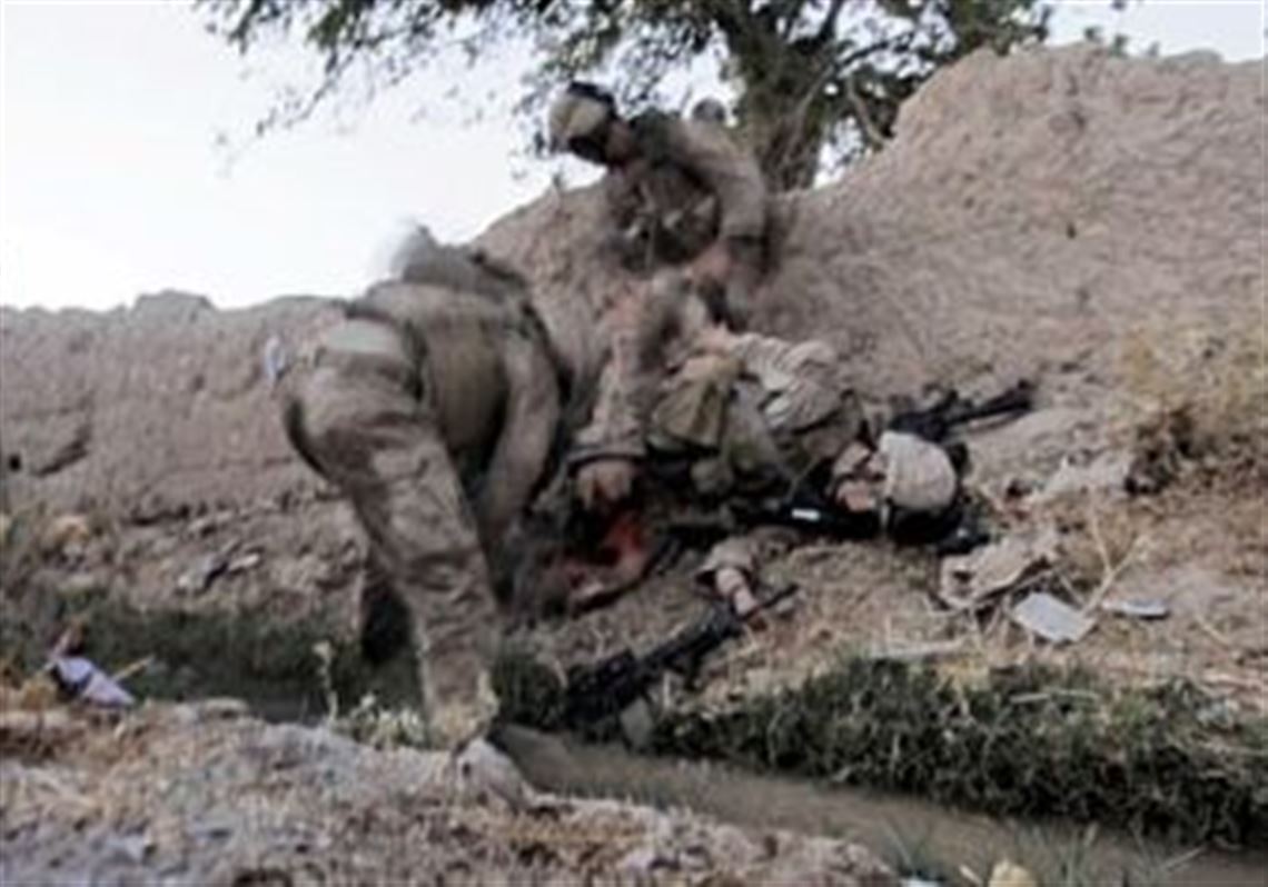 Fellow Marines tend to Lance Cpl. Joshua Bernard after he was hit by a rocket-propelled grenade in Afghanistan.  Lance Cpl. Bernard later died of his wounds,