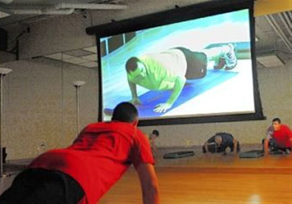 Steven Esposito, 15, watches the screen as he works out to a 30-minute "sports drills" program from Fitness on Request, a menu of exercises classes offered at Vygor Fitness.