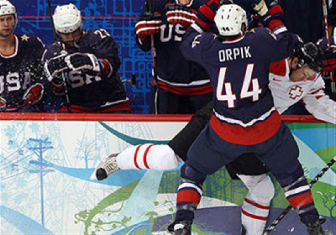 United States defensmean Brooks Orpik checks Switzerland forard Romano Lemm.