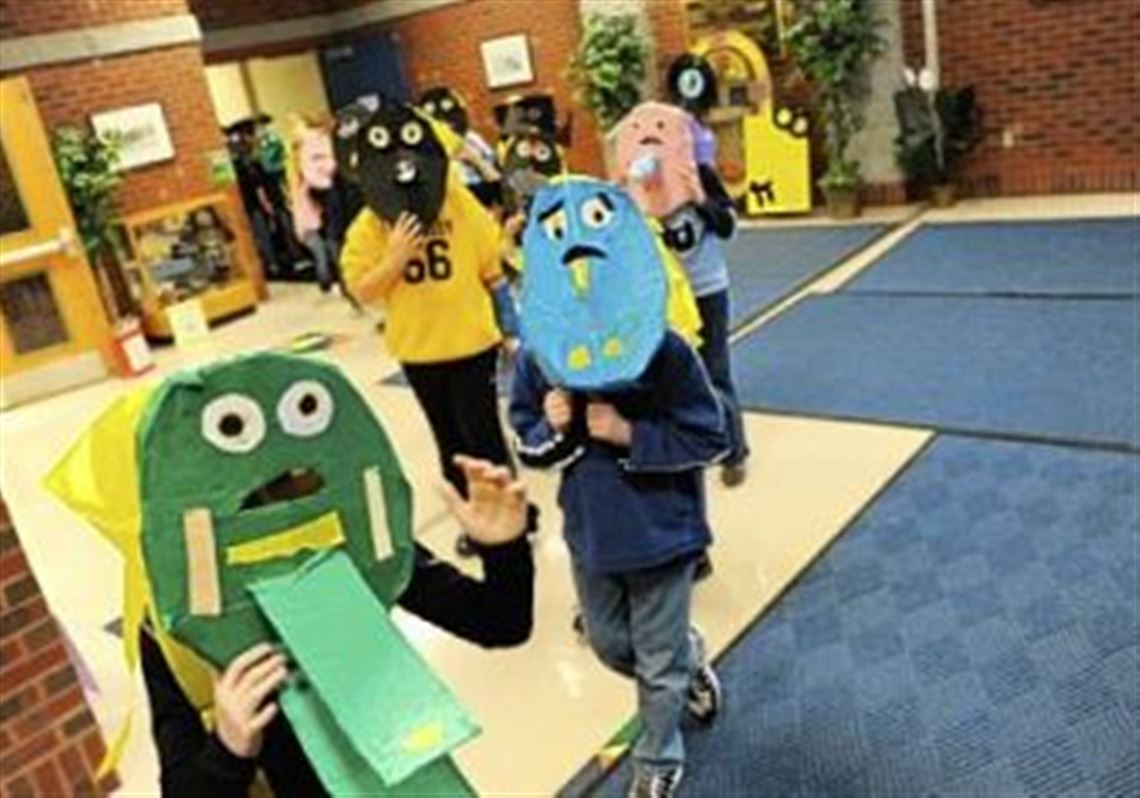 Fourth-grade students at South Park Elementary School march Monday in a parade of puppets they made out of recycled paper.