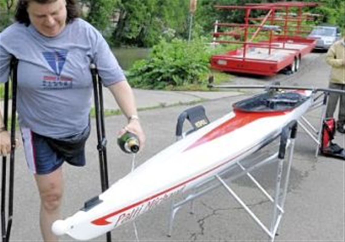 Local rower Patti Michaud christens a new adaptive boat, "Patti Michaud," at the Three Rivers Rowing Association.