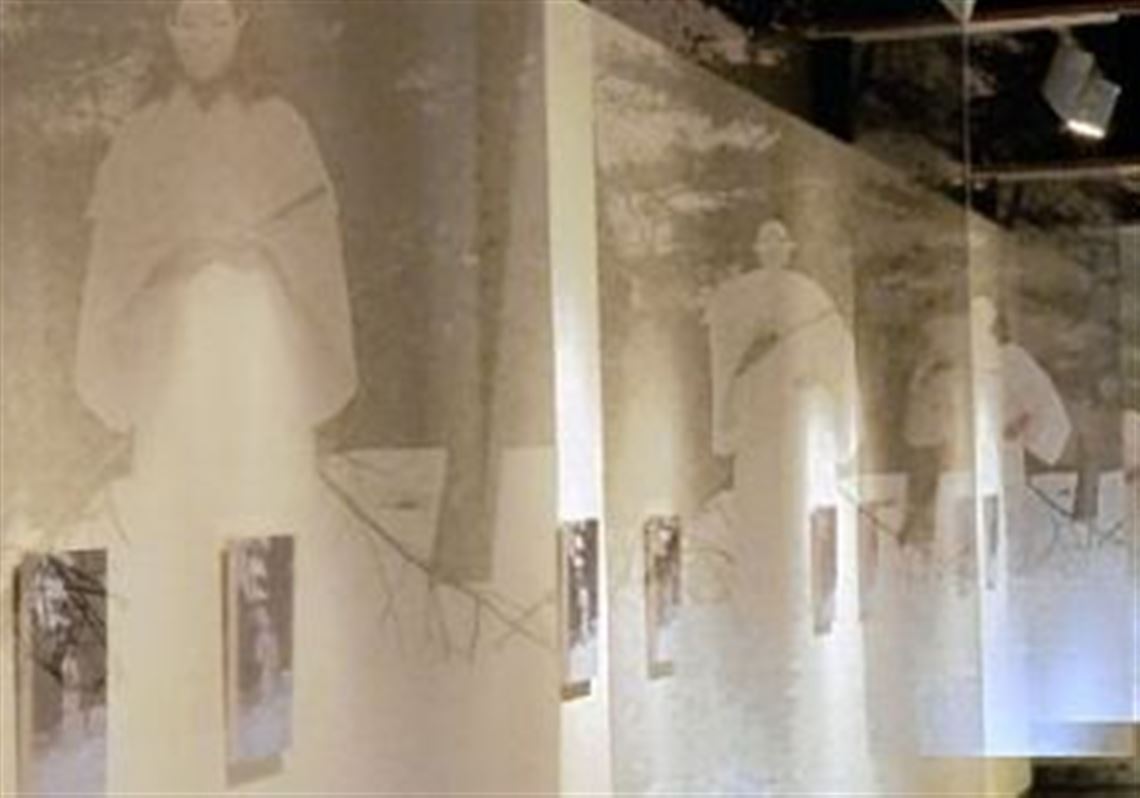 A detail of Fumino Hora's installation, "The Way of Samsara," at the Pittsburgh Glass Center. Organza banners imprinted with the image of a woman in a white kimono draw visitors into the gallery.