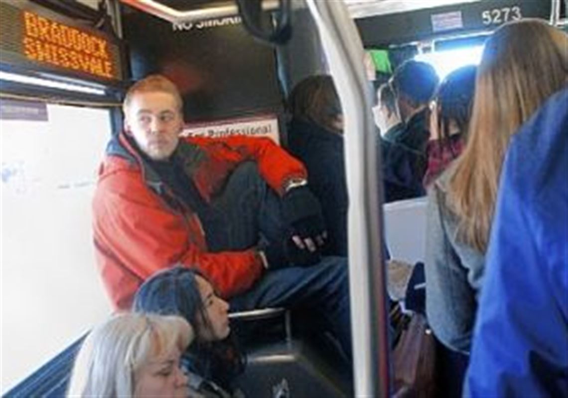 Dave Moore finds a secure, but not so comfortable, seat on the 61B bus as it heads up Forbes Avenue on Monday afternoon.