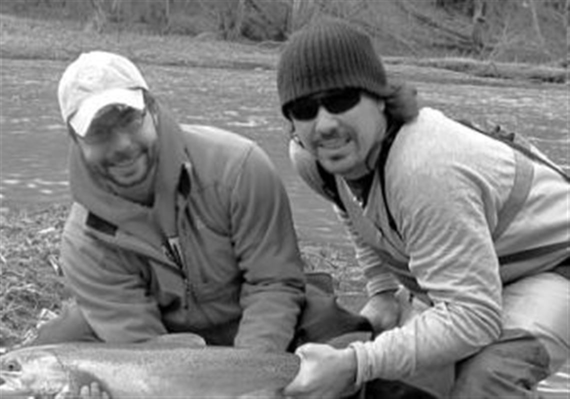 Don't hold big fish by the lip or gill plate. Jim Hockaday, left, of Dublin, Ohio, and fishing guide and Kype magazine editor George Douglas correctly hold a 12-pound female steelhead released in April on the upper Grand River in Ashtabula County, Ohio.