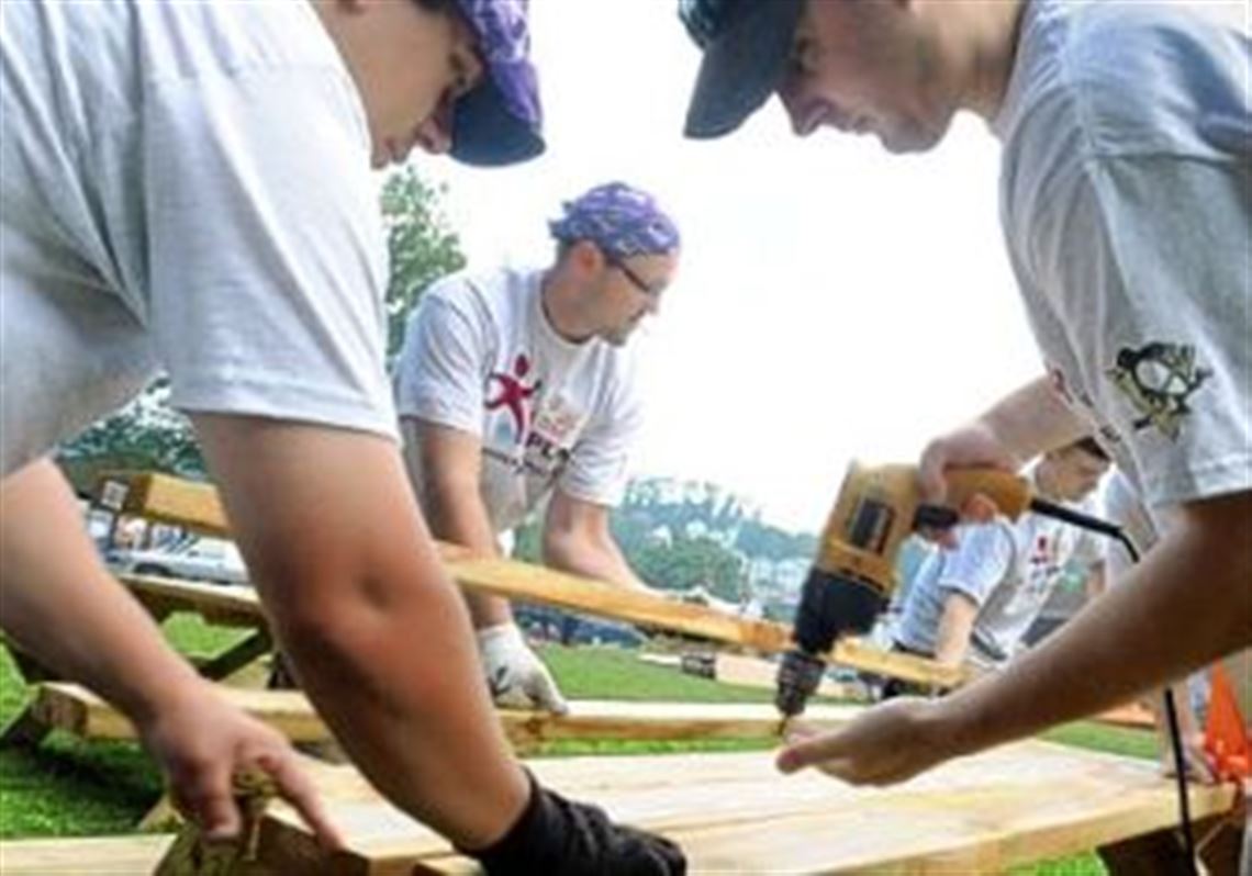 Working on the playground Friday in McKees Rocks are, from left, Danny Kroll of Castle Shannon, Penguins hockey head coach Dan Bylsma and George Murphy of the South Side.