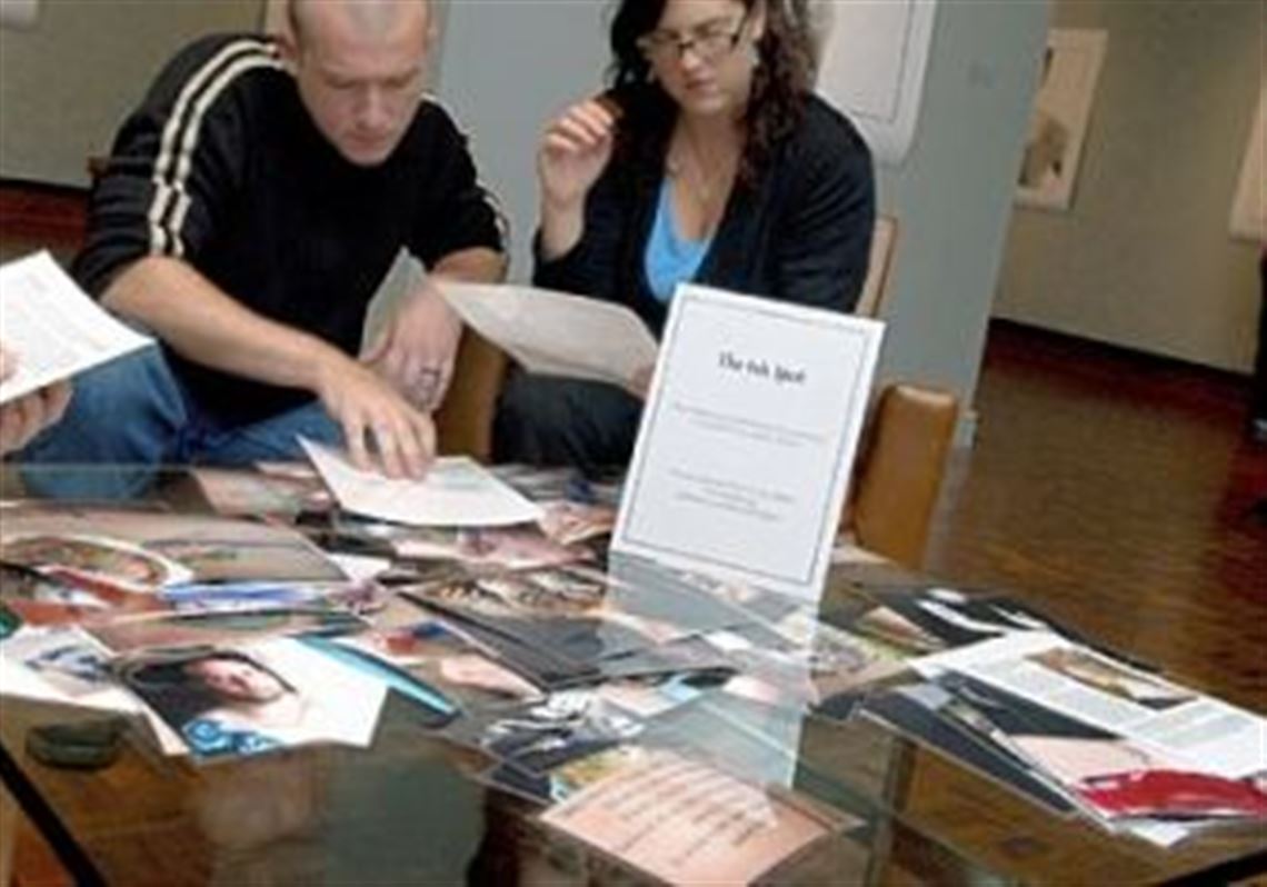 Visitors to the Westmoreland Museum of American Art check out "The Ink Spot" at Mark Perrott's photographic exhibition, "Tattoo Witness." Pre-show, the museum put out a call on Facebook for community members to submit pictures of their tattoos, and many responded. Those images were printed and laminated, along with their stories, for "The Ink Spot."