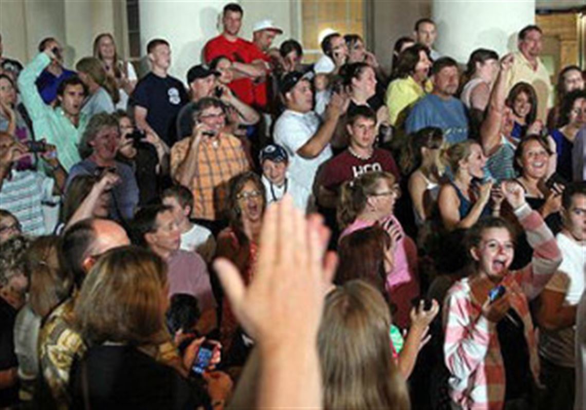 People gathered on the front steps of the courthouse cheer when they learn of the verdict.