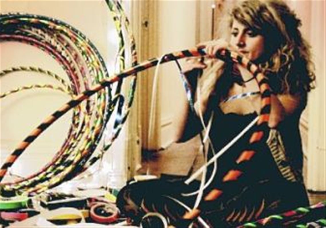 Artist Stefanie Moser decorates the hoops she'll use in a performance of hoop dancing.