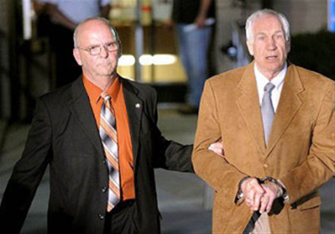Jerry Sandusky is led in handcuffs by Centre County Sheriff Denny Nau after being found guilty June 23 on 45 counts of sexual abuse at the Centre County Courthouse in Bellefonte.