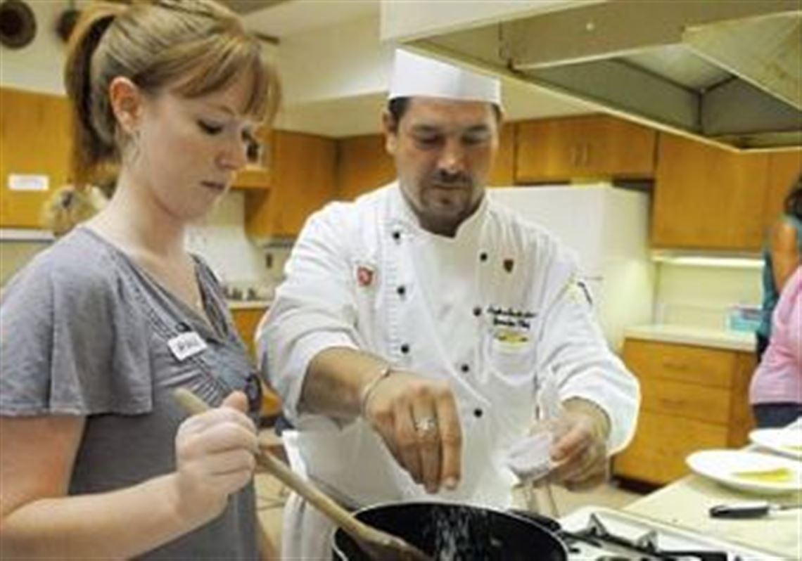 Amanda Petrovich of Fox Chapel helps Stephen J. Grottenthaler, executive chef of Pittsburgh Field Club, in a cooking class at Fox Chapel Area High School.