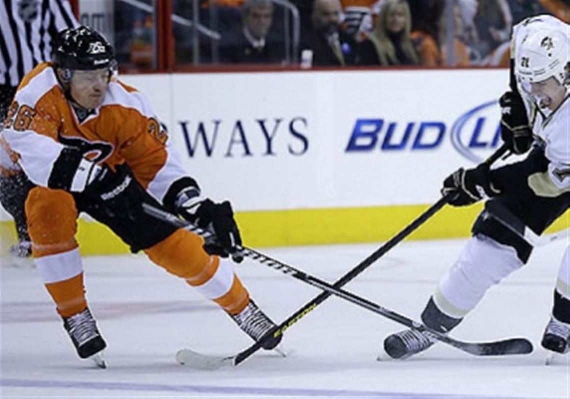 Evgeni Malkin, whose point streak continued in the win against the Flyers,  tries to control the puck between Ruslan Fedotenko (26) and Zac Rinaldo (36).
