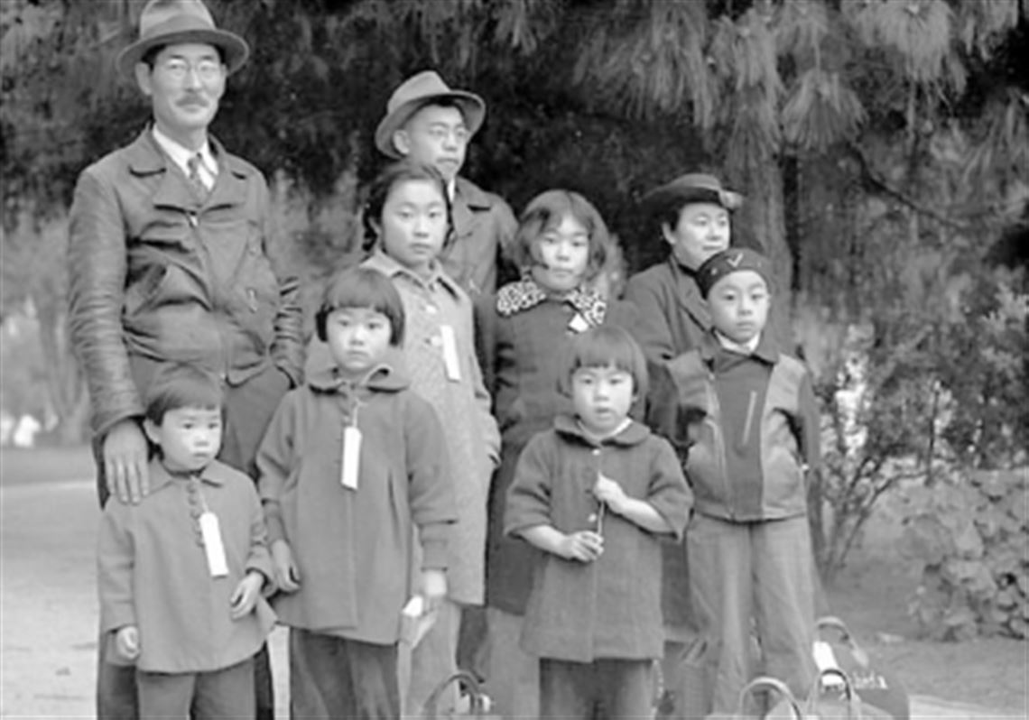 A May 1942 photo by Dorothea Lange shows members of the Mochida family awaiting a bus to take them to an internment camp. Identification tags were used to aid in keeping a family intact. The Mochidas operated a nursery and five greenhouses on a 2-acre site in Hayward, Calif. They were among 110,000 people of Japanese descent placed in internment camps.