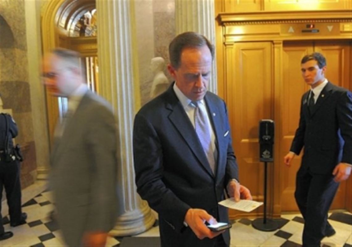 Sen. Pat Toomey checks his schedule outside the Senate chambers in February.