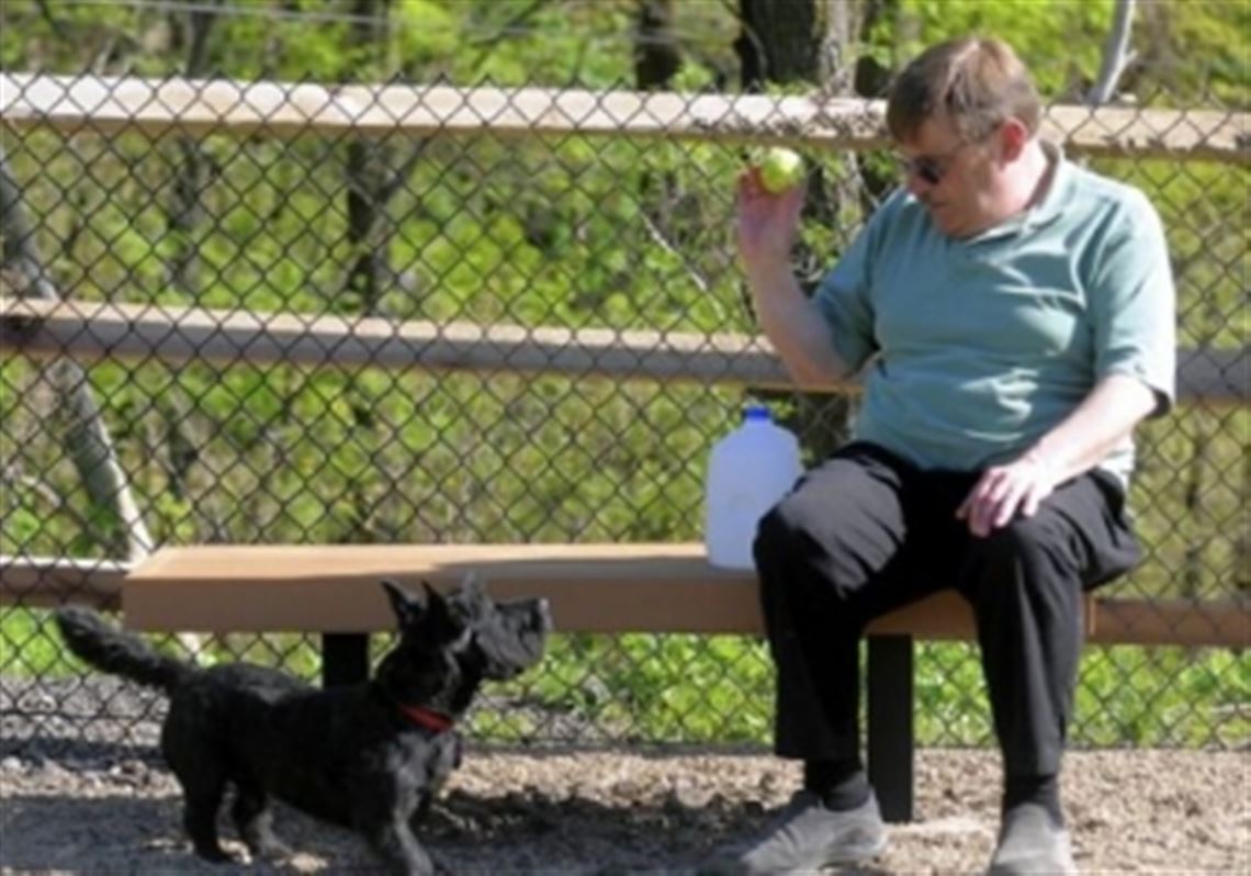 Wil Klipfel of Scott and his dog, Jake, use Carnegie's new dog park == a free, fenced area in for pets off of Forsythe Road.