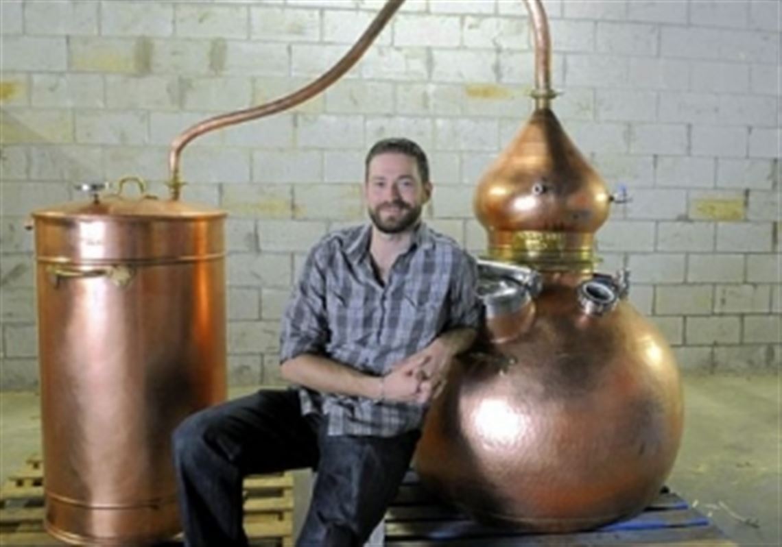 Tim Russell with his Spanish-made still, with which he plans to make rum and perhaps other spirits in the Strip District.