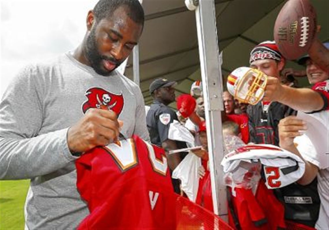 Aliquippa High School graduate Darrelle Revis signs autographs after a training camp practice last month in Tampa, Fla. Revis was traded to the Buccaneers in the offseason.