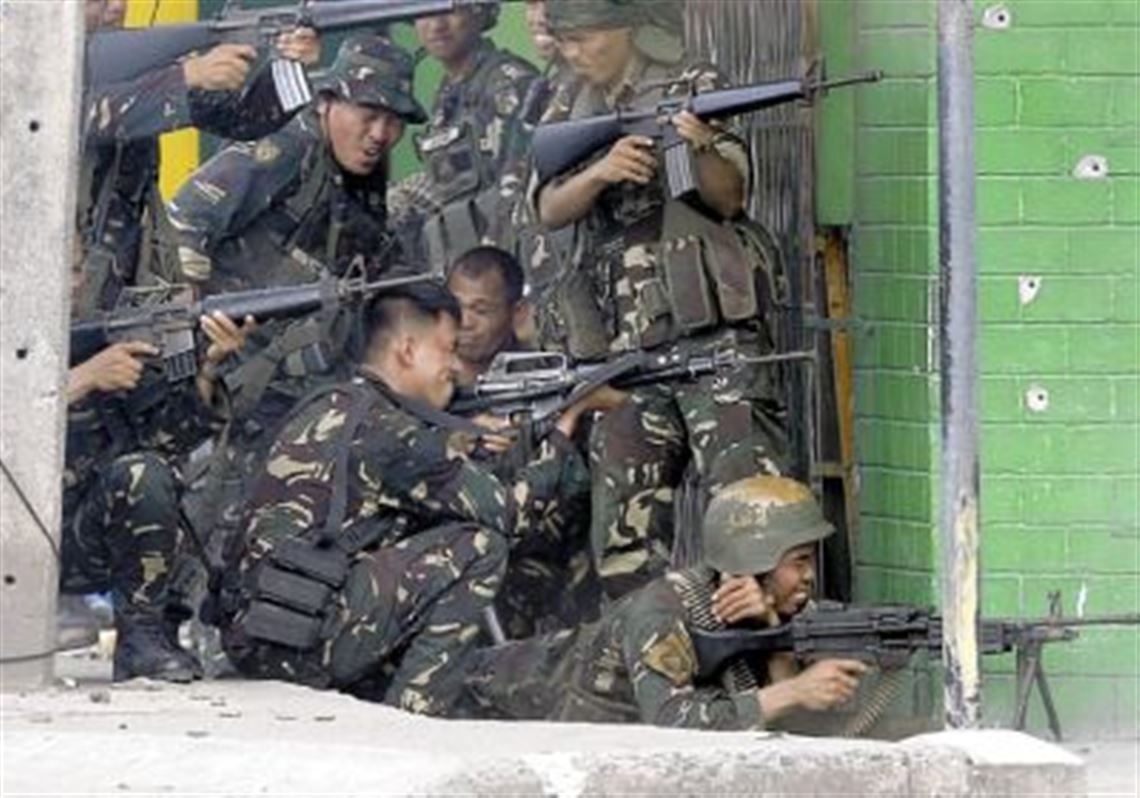 Government troopers fire their weapons Thursday as they continue their assault against Muslim rebels in Zamboanga, Philippines.