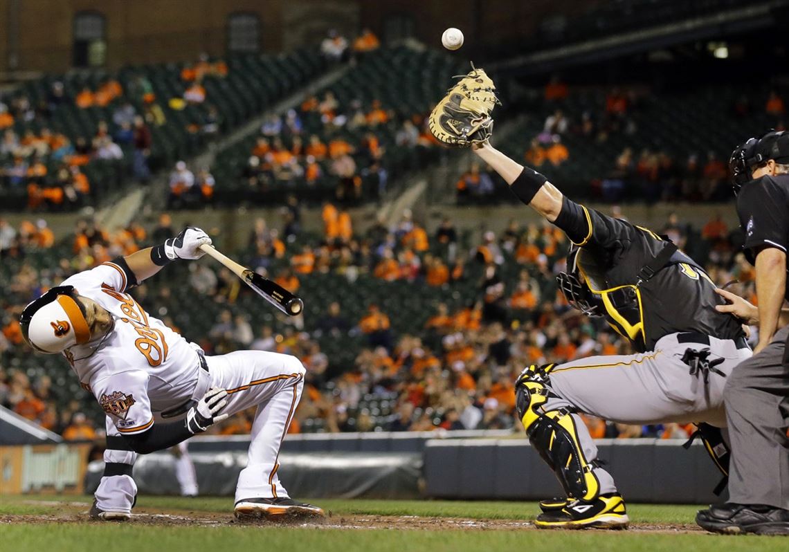 The Orioles' Manny Machado, left, ducks as Pirates catcher Tony Sanchez tries to catch a wild pitch in the fourth inning in the second game of a doubleheader in Baltimore.