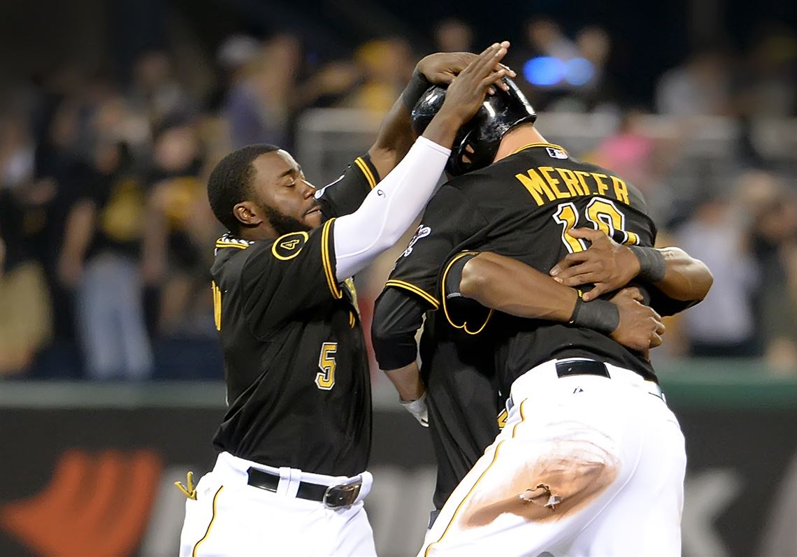 The Pirates' Jordy Mercer is mobbed after hitting a game winning single against the Rockies in the 11th inning at PNC Park on Saturday.