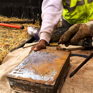 Workers open the time capsule they found while demolishing the building that once housed the factory in which John Brashear manufactured optics.