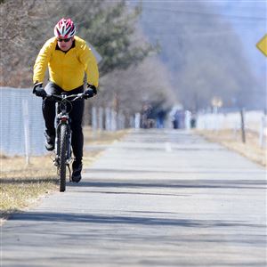 A cyclist rides the Armstrong Trail through Ford City on a chilly, sunny Sunday.