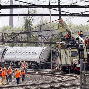 Investigators Wednesday examine the wreckage of an Amtrak derailment in north Philadelphia the night before.