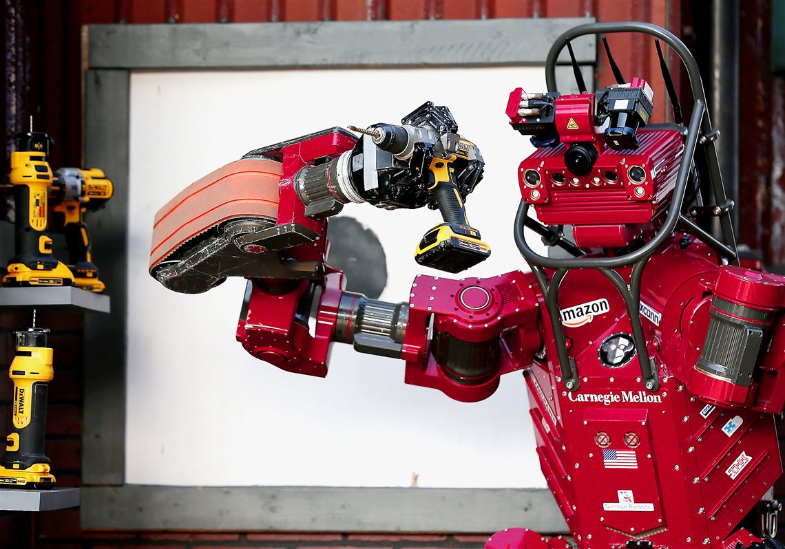 Team Tartan Rescue's CHIMP (CMU Highly Intelligent Mobile Platform) robot uses a hand-held power tool during the cutting task Saturday in the Defense Advanced Research Projects Agency's Robotics Challenge in Pomona, Calif.