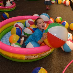Gino Markovina, 5, of Hempfield, plays with beach balls in the theater area of the Children's Museum on free admission day at the museum to kick off summer.
