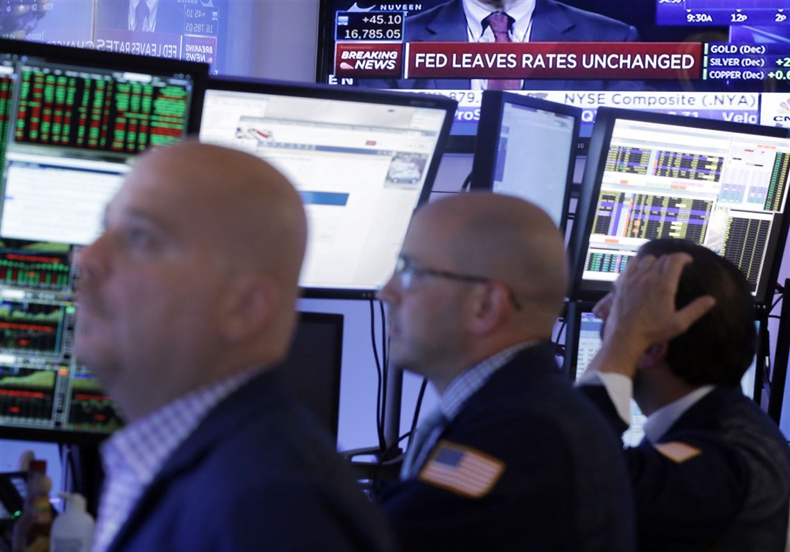 Traders work in a booth on the floor of the New York Stock Exchange, Thursday, Sept. 17, 2015. The Federal Reserve is keeping U.S. interest rates at record lows in the face of threats from a weak global economy, persistently low inflation and unstable financial markets. (AP Photo/Richard Drew)