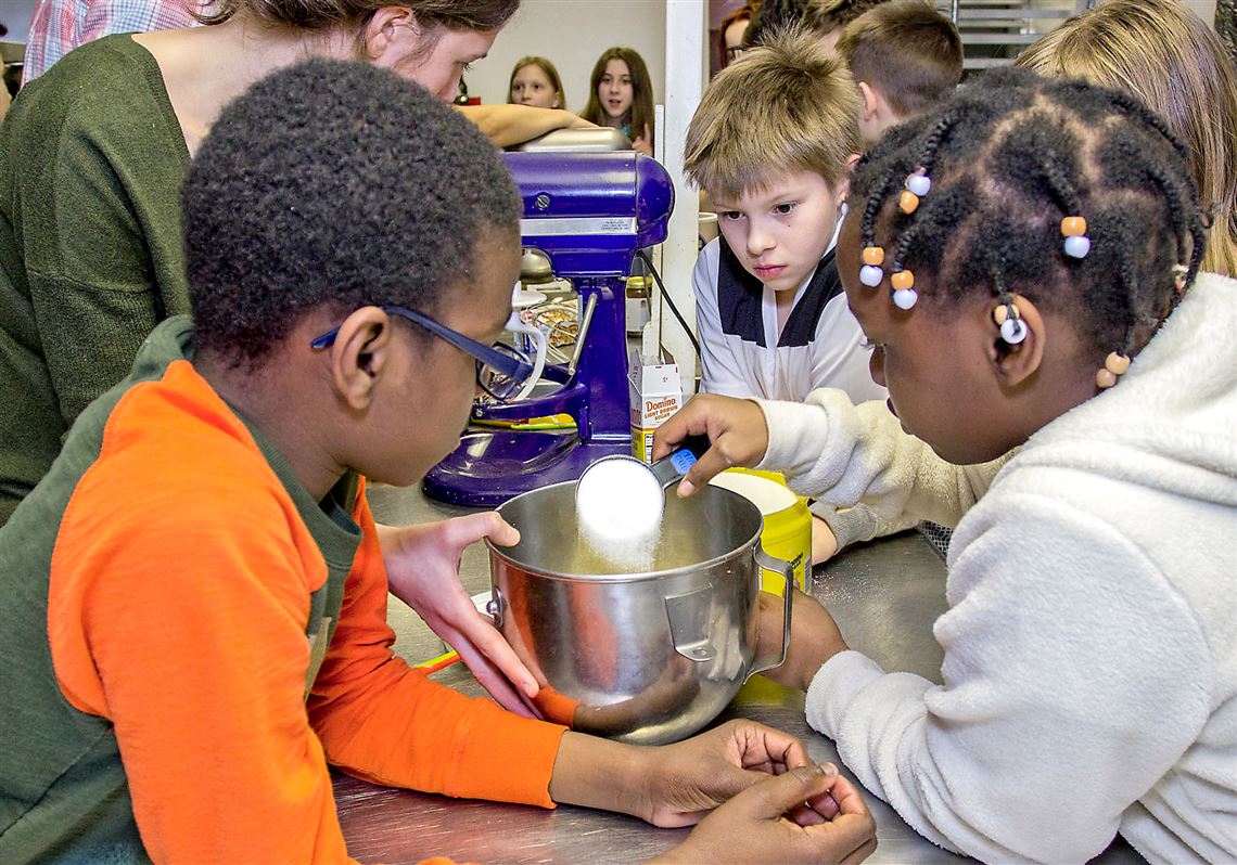 From left, Matthew Sheeler, Aden Whitlinger and Celeste Chitambo work on measuring sugar for oatmeal chocolate-chip cookies. 