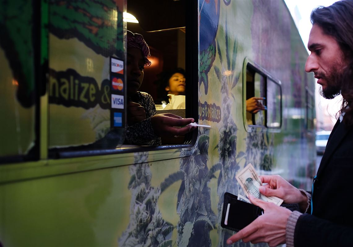 A person makes a purchase from a Weed World Candies truck as it sits parked on lower Broadway on Sunday in New York City.