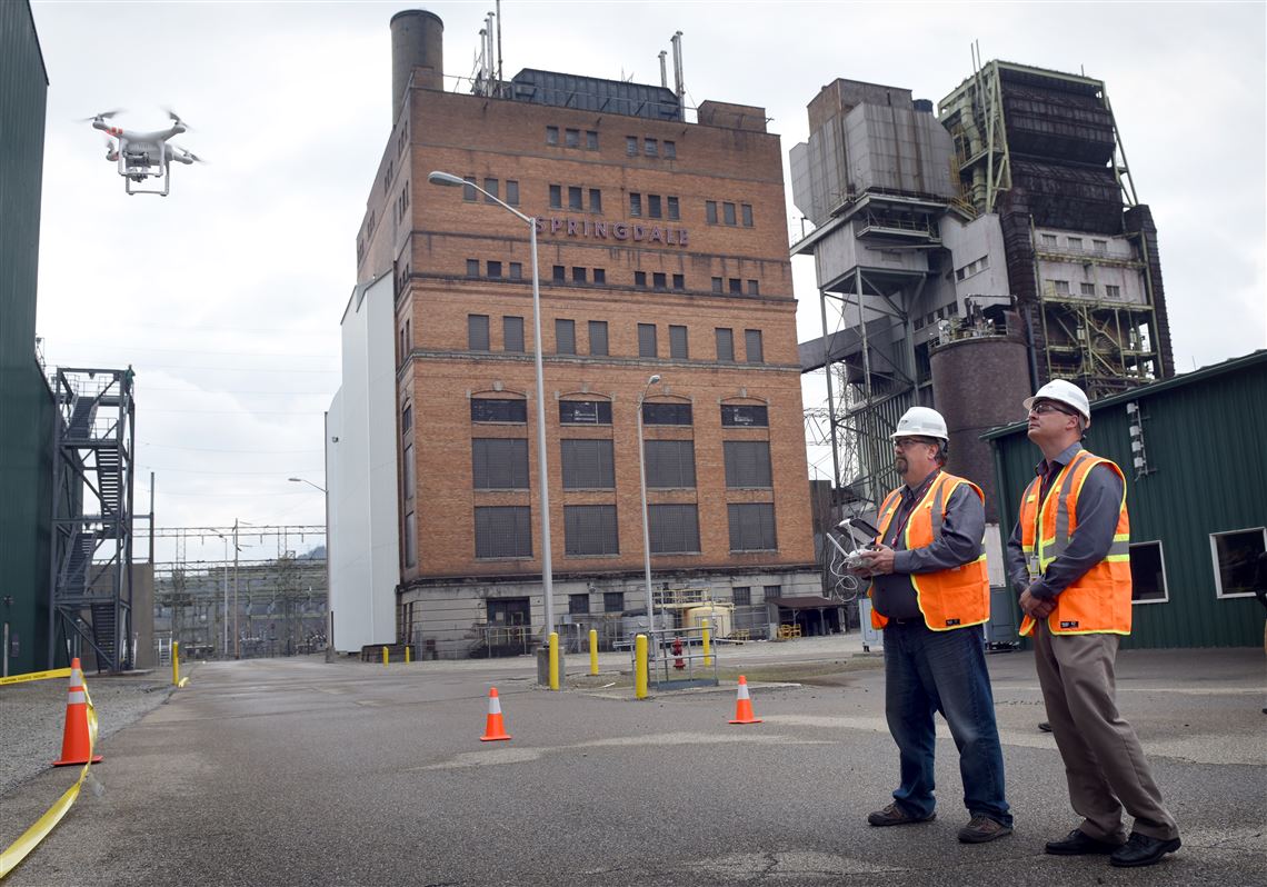 Ric Musselman (left) and Shawn Theiss of Theiss Unmanned Aerial Vehicle Solutions guide a drone aircraft as it begins to record video and pictures of the heat recovery steam generator at FirstEnergy's natural gas plant in Springdale. Drones are a cheaper and safer method of conducting inspections, company officials said.