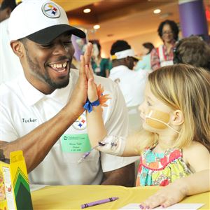 Steelers rookie Marcus Tucker gives Genevieve Mehler, 2, of Meadville, a high-five after finishing a puzzle game today at the Children’s Hospital of Pittsburgh of UPMC.