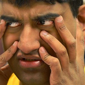 Tejus Sharathchandra, 20, reacts as he folds letters at the Vocational Training Center of Western Psychiatric Institute and Clinic of UPMC on the South Side.