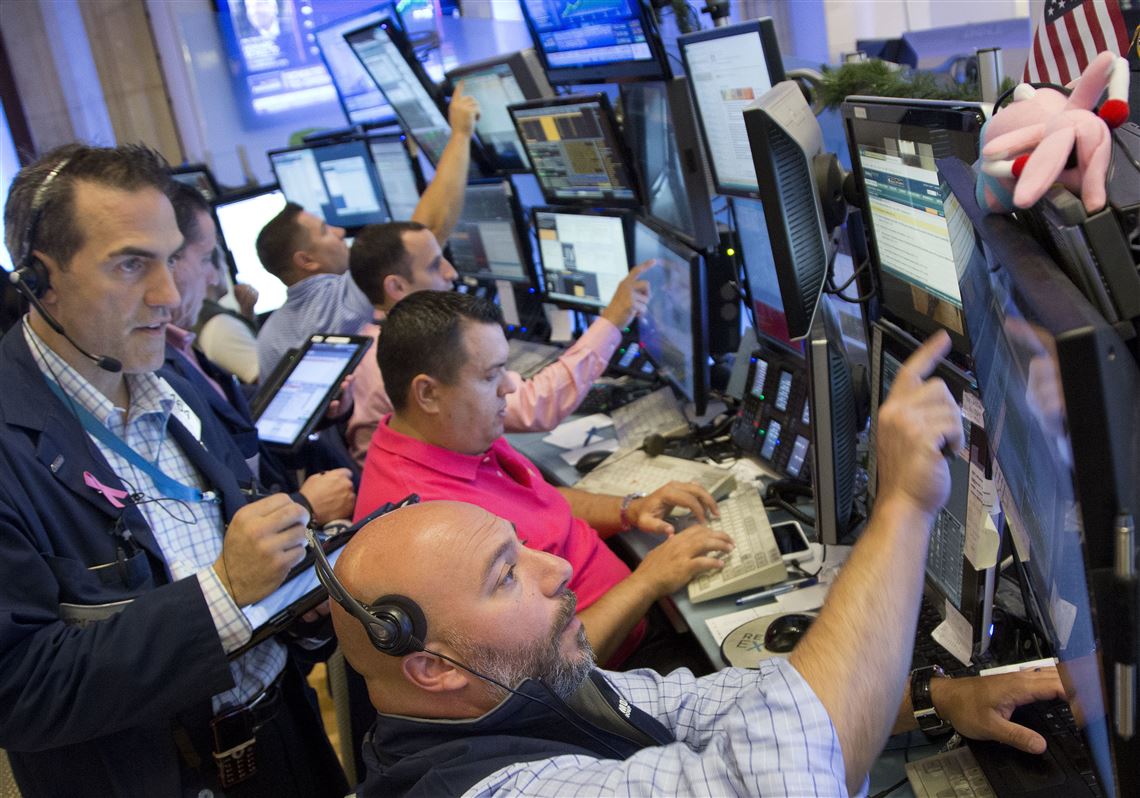 People pass in front of the New York Stock Exchange, Friday, July 22, 2016, in New York. (AP Photo/Mark Lennihan)
