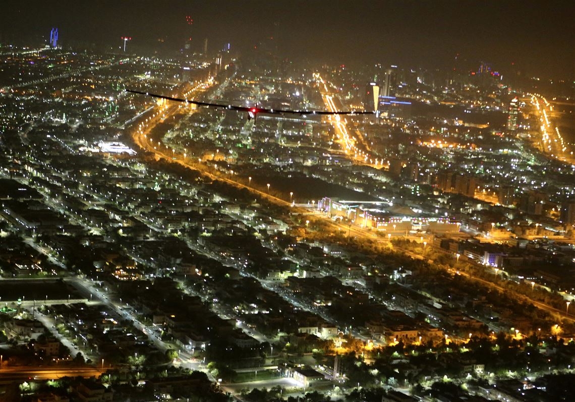 The Solar Impulse 2 plane flies over Abu Dhabi, United Arab Emirates, shortly before landing on Tuesday, July 26, 2016. The world's first ever round-the-world flight to be powered solely by the sun's energy made history with its landing in the Emirati capital, where it first took off more than a year ago. (AP Photo/Adam Schreck)