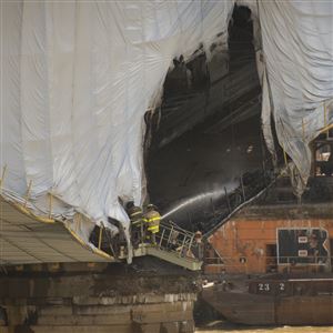 Pittsburgh firefighters spray down a section of the Liberty Bridge where a tarp fire raged Friday afternoon, shutting down the bridge.