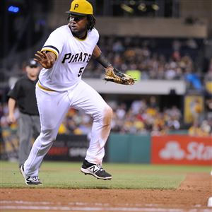 Josh Bell signals to catcher Francisco Cervelli that he can reach the base for a putout in the fifth inning Sept. 3 against the Milwaukee Brewers.