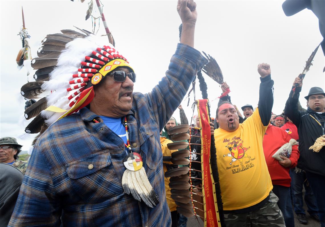JR American Horse, left, raises his fist with others while leading a march to the Dakota Access Pipeline site in southern Morton County North Dakota. Several hundred protesters marched about a mile up Hwy 1806, Friday Sept. 9, 2016, from the protest camp to the area of the pipeline site where some archeological artifacts have been discovered. (Will Kincaid/The Bismarck Tribune via AP)