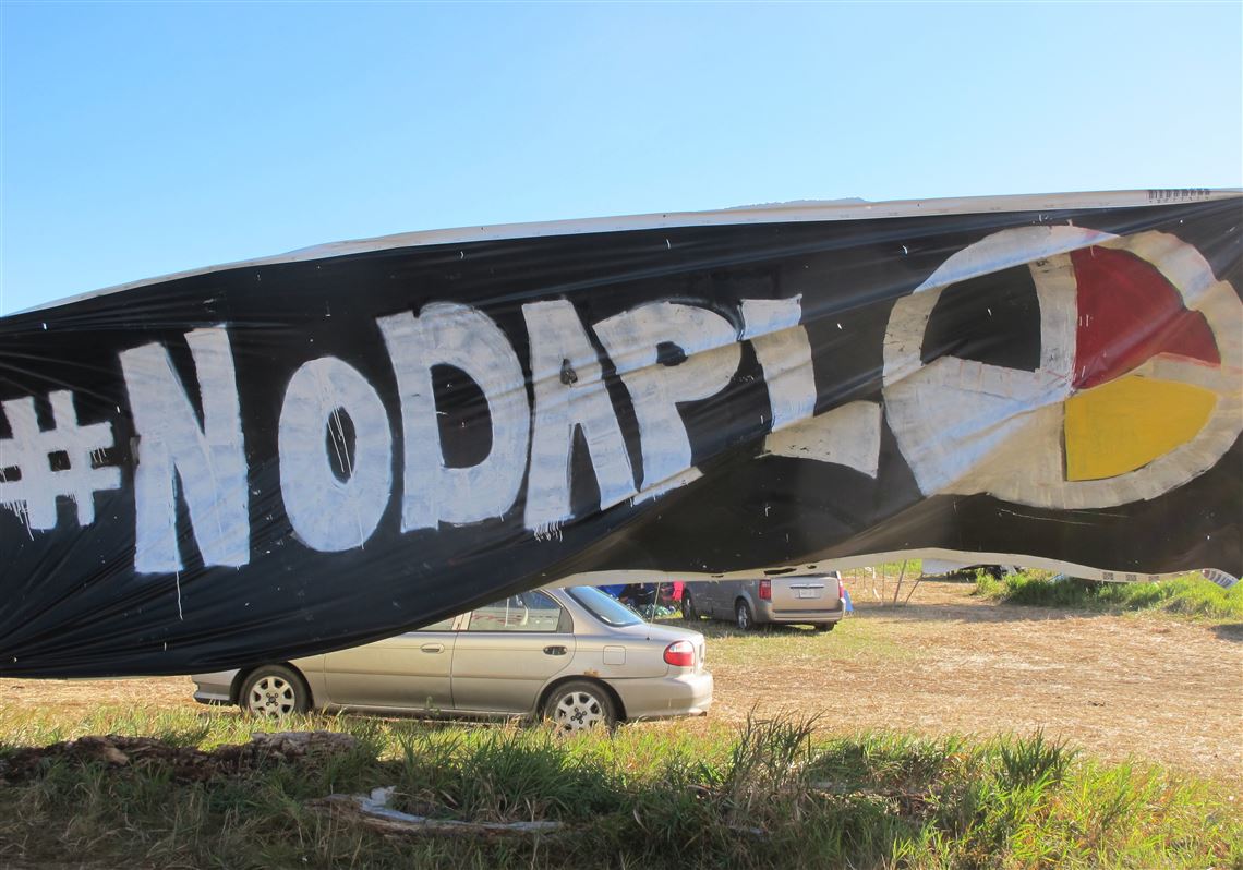 A banner protesting the Dakota Access oil pipeline is displayed at an encampment near North Dakota's Standing Rock Sioux reservation on Friday, Sept. 9, 2016. The Standing Rock Sioux tribe's attempt to halt construction of an oil pipeline near its North Dakota reservation failed in federal court Friday, but three government agencies asked the pipeline company to "voluntarily pause" work on a segment that tribal officials say holds sacred artifacts. (AP Photo/James MacPherson)